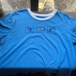 A light blue and white top with decorative flower patches